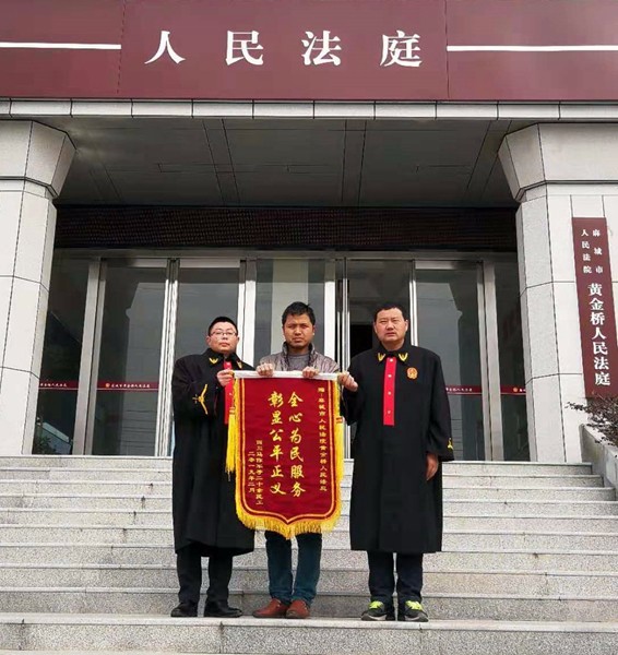 马某送锦旗给法官.jpg