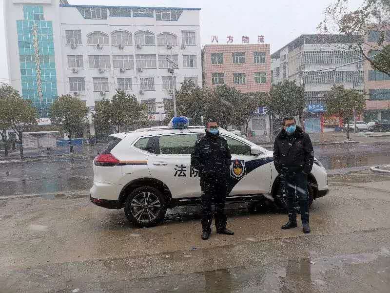 麻城市法院法警大队副队长杨强（左）在雪中值守.jpg